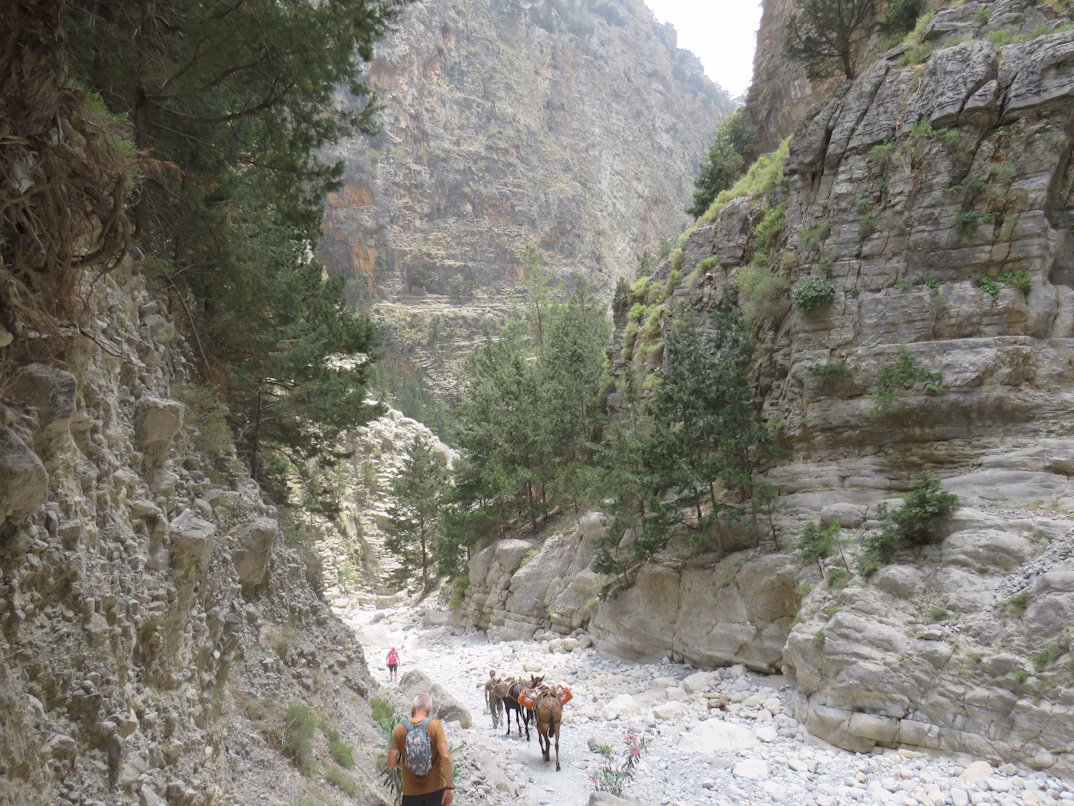 Hikers crossing a stone bridge in Samaria Gorge, Crete