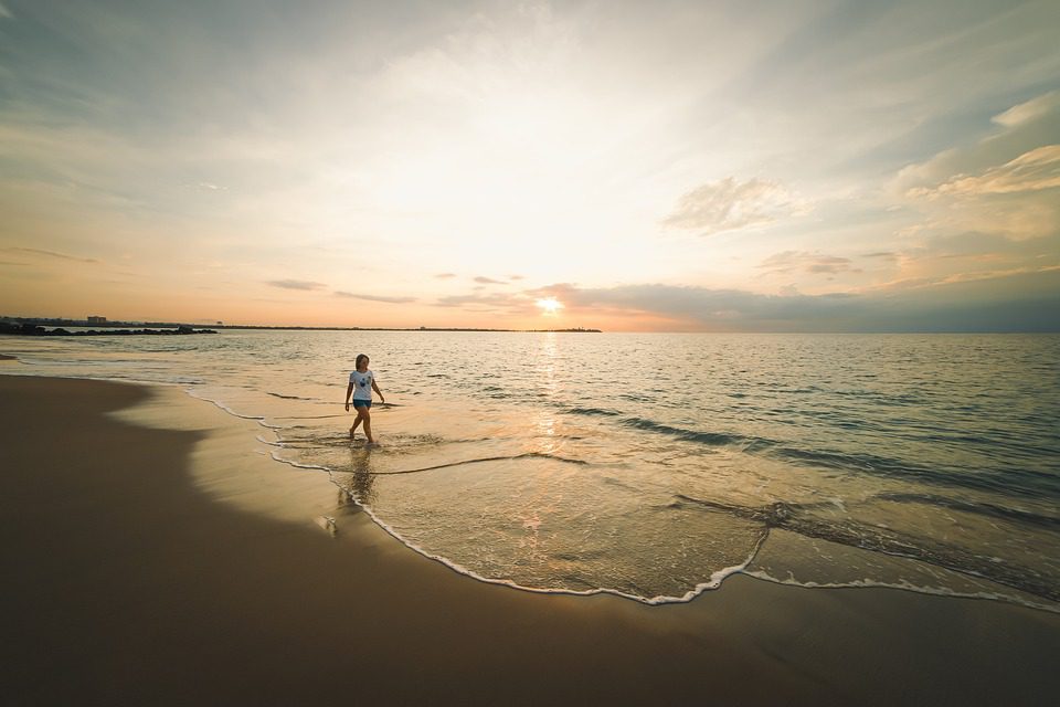 Stunning beach sunset with a woman by the sea in Ras Al Khaimah